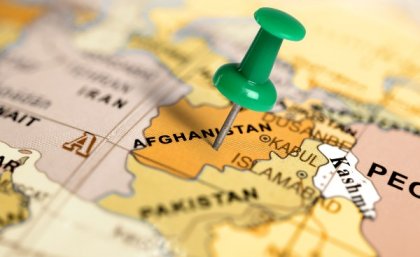 Thumbtack stuck on Afghanistan on world map.